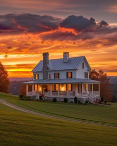 a large white house sitting on top of a lush green field under a cloudy sky