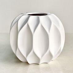 a white vase sitting on top of a table