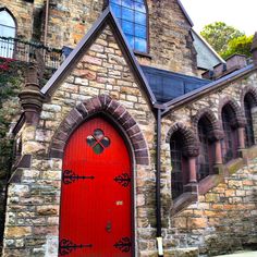 an old church with a red door and arched windows