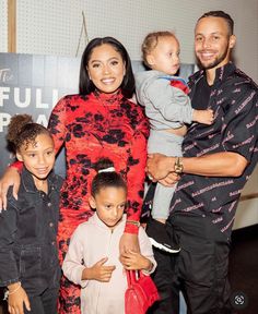 a man, woman and two children standing in front of a sign that says the full house