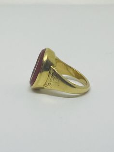 "This is a vintage 18K (high-karat) yellow gold Cameo-design statement ring. Definition of a \"cameo\": a piece of jewelry, typically oval in shape, consisting of a portrait in profile carved in relief on a background of a different color. Material(s): 18K yellow gold + unidentified material (cameo) Total weight: 12.2 grams Flaws (if any): None to mention Marking(s): \"18ct\" (translating to 18K gold) Measurements: The face of the ring measures 17.9 millimeters in height by 5.8 millimeters in wi Vintage 14k Gold Cameo Rings, Formal Gold Cabochon Signet Ring, Antique 14k Gold Signet Ring With Cabochon, Vintage Yellow Gold Cameo Rings, Antique Yellow Gold Round Signet Ring, Antique Gold Ruby Ring Stamped 14k, Antique Yellow Gold Intaglio Jewelry, Antique Gold Signet Ring Collectible, Classic Yellow Gold Signet Ring With Cabochon