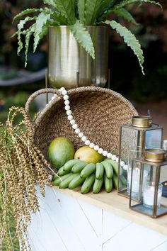 a basket filled with bananas and other fruit on top of a table next to a candle