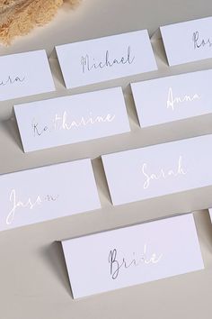 place cards with names on them sitting next to a teddy bear and some other items