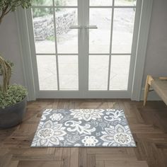 a living room with wooden floors and a large glass door that leads to a patio