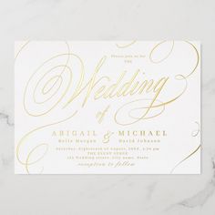 a white and gold wedding card with the word,'wedding'written on it