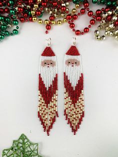 beaded santa claus earrings with red, white and green beads next to christmas decorations