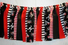 a black and red striped skirt with skulls and crossbones is hanging on the wall