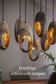 an assortment of lights hanging from the ceiling in a room with wooden table and chairs