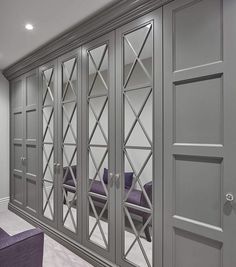 a room that has some purple chairs and gray cabinets on the wall in front of it