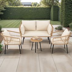 an outdoor patio with white furniture and greenery