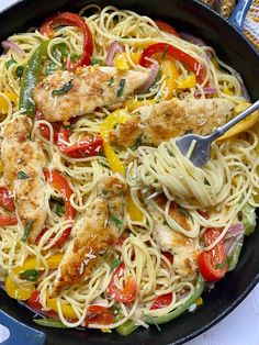 a skillet filled with chicken, pasta and veggies on top of a table