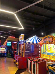 an indoor play area with carnival rides and games