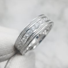 a white gold wedding ring with princess cut diamonds