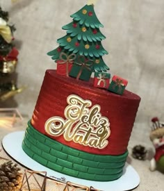 a red and green christmas cake sitting on top of a table next to other holiday decorations