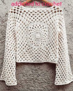 a white crocheted sweater hanging on a clothes hanger with the words, how to