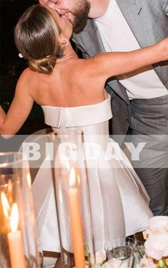 a bride and groom kissing in front of candles at their wedding reception with the words big day written on it