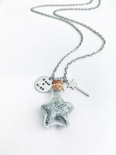 This stainless steel necklace would make a wonderful gift of luck to anyone looking for a little magic. It is hand stamped by me and it features: - a glass bottle (23x21mm) full of silver glitter - a wand charm (20mm long) - an aluminum circle tag (16mm) Personalization: - Choose from the drop down option the length of the necklace and the color of the glitters inside the bottle. IMPORTANT: the cork has been securely glued in place but the bottle is made of glass so it can breakplease handle wit Handmade Silver Charm Necklace With Magical Style, Magical Silver Charm Necklaces As Gift, Whimsical Star Charm Jewelry As Gift, Magical Silver Charm Necklaces For Gift, Whimsical Star Charm Jewelry Gift, Bottle Charms Necklaces, Spell Bottle Necklace, Fairy Jar Necklace, Necklace Vial