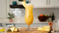 a pineapple drink sitting on top of a wooden cutting board