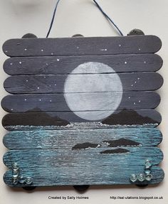 a wooden sign with the moon and water painted on it