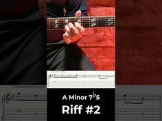 an image of a man playing guitar with sheet music in front of him and the caption reads, a minor'75 riff 2