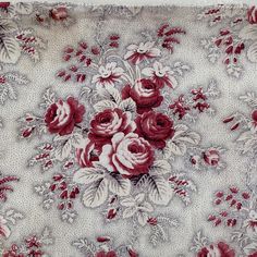 a red and white floral print fabric with roses on the reverse side is shown in full bloom