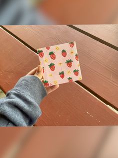 a person holding up a small box with strawberries on it