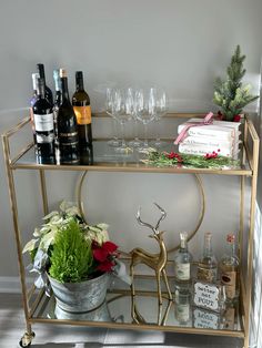 a gold bar cart with wine glasses and bottles