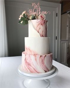 a three tiered cake with pink and white marble