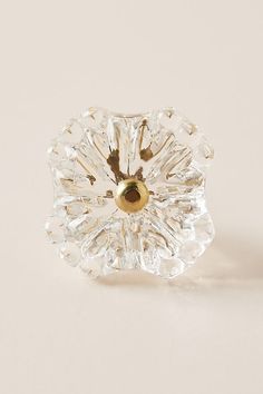 an image of a glass object on a white surface with a gold ring in the middle