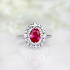 Beautiful Vintage Inspired Ruby Ring Made of Solid Sterling Silver, Rhodium Plated (925) Can be paired with one or two half-eternity Milgrain bands of your choice Accented with Simulated Diamonds (CZ) Center Stone: Ruby Grade: AAA Stone Cut: Oval Gem size: 7.0 x 5.0 mm Carat Weight: 0.76 (approx.) Gemstone creation: 100% Genuine Lab-Grown Ruby Stone Origin: Russia Handling time: 1-2 business days Free domestic shipping. Usually takes 2-5 business days. Wrapped & ready to give in a beautiful Classic Promise Jewelry With Lab-created Ruby, Classic Lab-created Ruby Jewelry For Promise, Classic Ruby Halo Ring, Anniversary White Gold Ruby Ring With Halo, Classic Ruby Ring With Halo Setting For Promise, Classic Halo Ruby Promise Ring, Classic Ruby Promise Ring With Center Stone, Anniversary Ruby Ring With Halo Design In Cubic Zirconia, Classic Lab-created Ruby Jewelry For Wedding