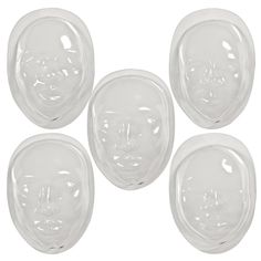 four clear plastic face plates on a white background