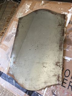 an old mirror sitting on top of a cardboard box