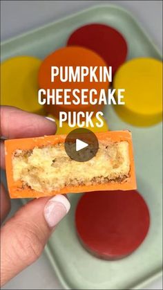 a person holding a piece of food in their hand with the words pumpkin cheesecake pucks on it