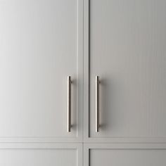 two white cupboards with metal handles on them