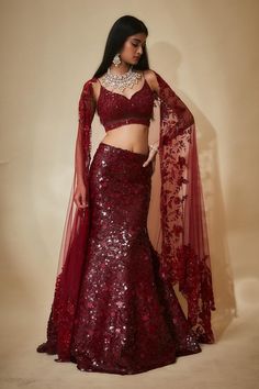 Burgundy mermaid lehenga with an attached cancan and sequins hand embroidery. Comes with a padded blouse and a floral work dupatta.
Components: 3
Pattern: Hand embroidered
Type Of Work: Sequins, Floral
Neckline: Leaf Neck
Sleeve Type: Sleeveless
Fabric: Tulle, Sequins georgette, Buttercrepe
Color: Maroon
Other Details: 
Heavily embroidered blouse
Lehenga length : 45 inches
Occasion: Destination Wedding - Aza Fashions Saree Choli Design, Mermaid Tail Lehenga, Burgundy Bridal Lehenga, Ladies Sangeet Outfit, Red Floral Lehenga, Sangeet Theme, Mermaid Lehenga, Maroon Lehenga, Blouse Lehenga