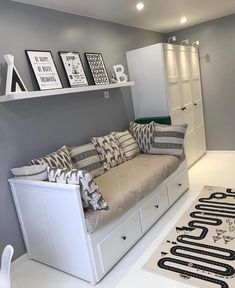 a living room filled with lots of furniture next to a white rug and wall mounted bookshelves