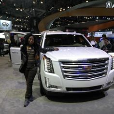 a woman standing next to a white car on display