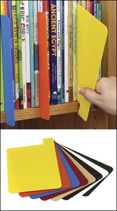 there is a book shelf with many books on it and a hand holding a yellow folder