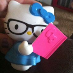 a hello kitty toy holding a pink tag