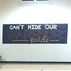 a sign that says can't hide our warrior pride on the side of a basketball court