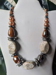 a necklace with brown and white beads on a mannequin