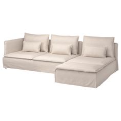 a white couch with pillows on it and a pillow that is folded over the back