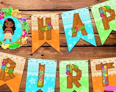 a banner that says happy birthday with flowers and leaves hanging from the side on a wooden table