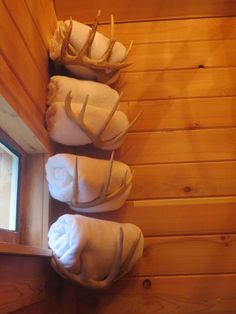 towels are lined up in the corner of a cabin with deer antlers on them