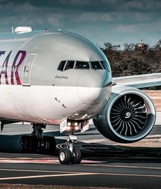 a large jetliner sitting on top of an airport tarmac next to a runway