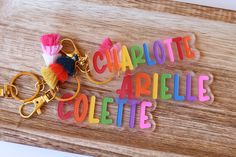 the name charlotte are spelled with colorful letters and tassels on a wooden board