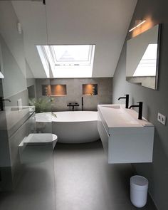 a modern bathroom with skylights above the bathtub and sink, is shown in white