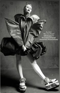 a black and white photo of a woman in a dress with wings on her head