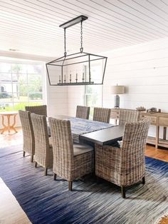 a dining room table and chairs with a rug on the floor in front of it