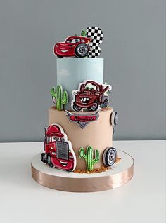 a three tiered cake with cars on it